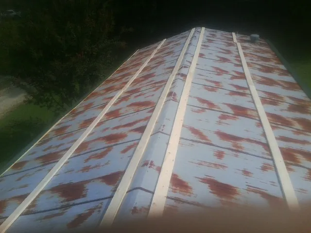 Rusted metal roof panels with new wood purlins before replacement — Storm Damage Roof Repair in Barataria by Roofing Brothers