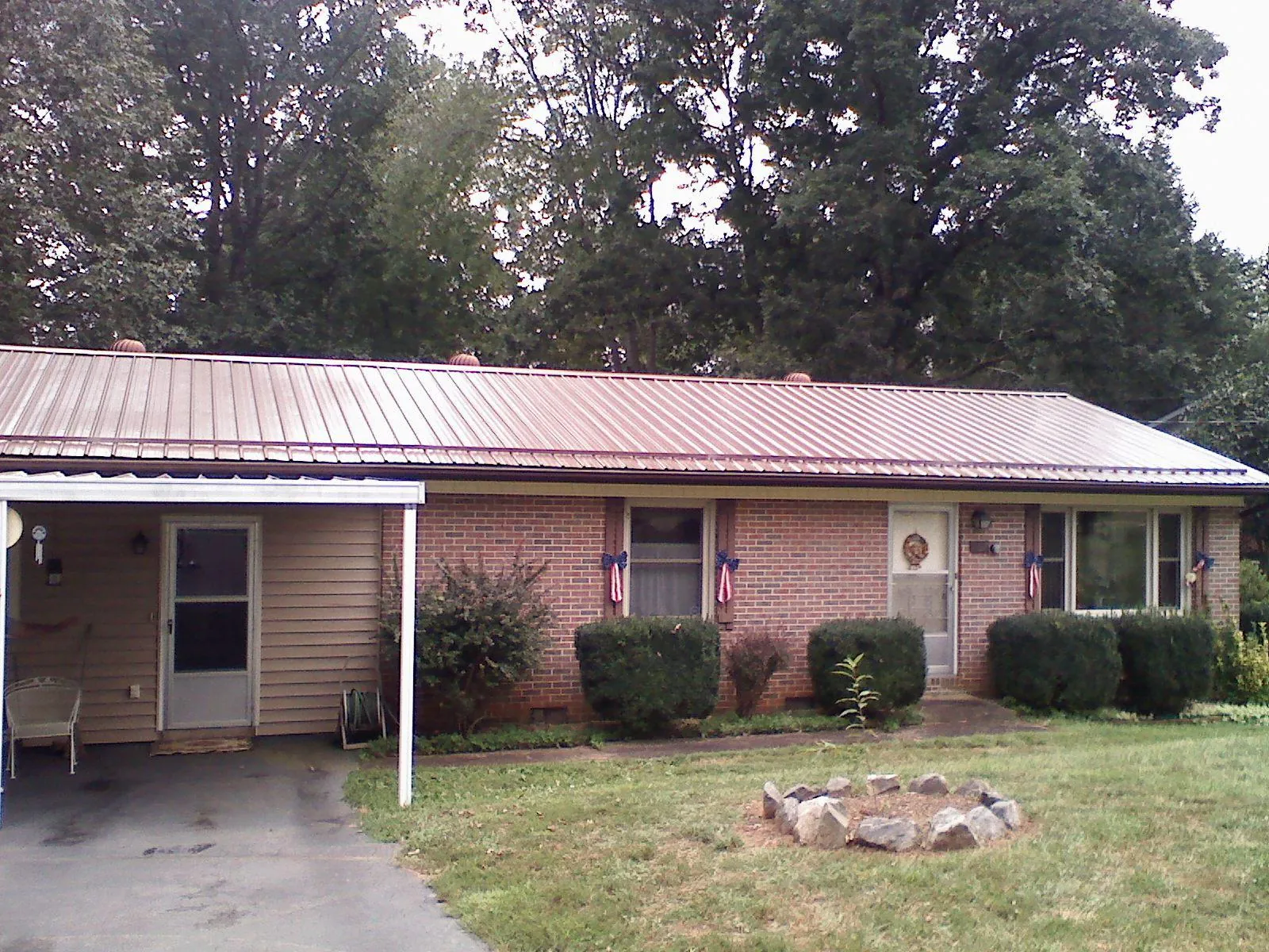 Bronze metal roof and carport on a brick ranch home — Roof Repair work by our crew in Barataria