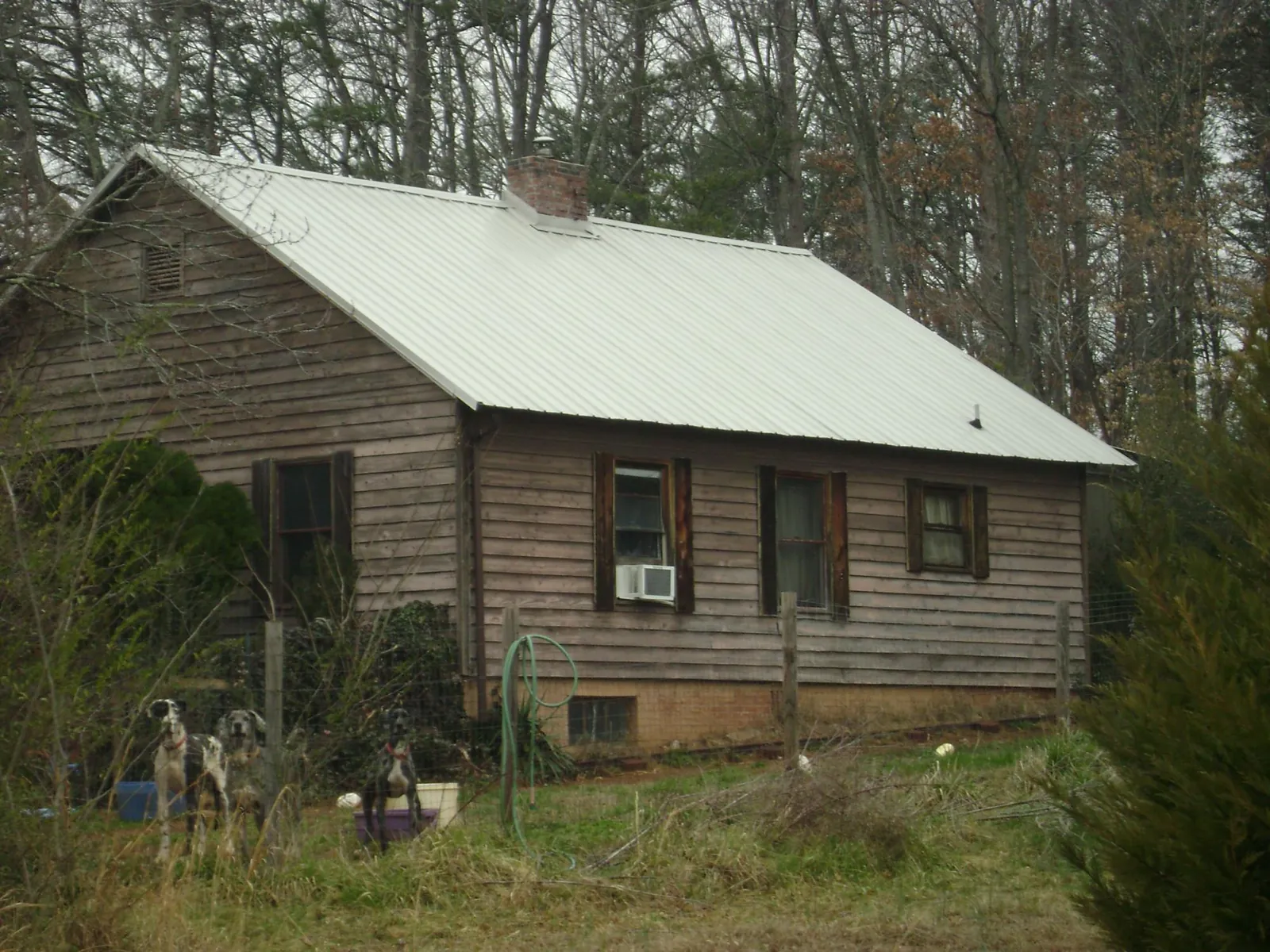 White metal roof on an old wood sided farmhouse, from a Metal Roof Installation job in Barataria